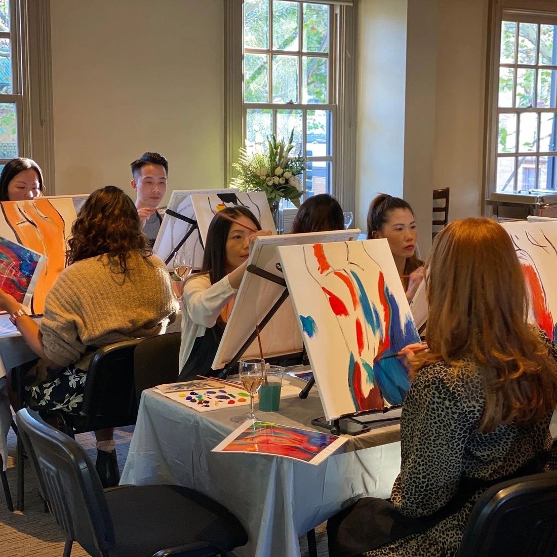 Guests painting at a bright venue transformed into an art studio