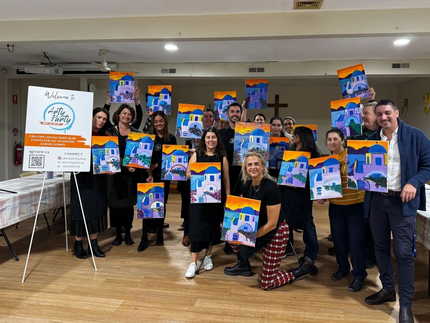A team holding up their finished paintings