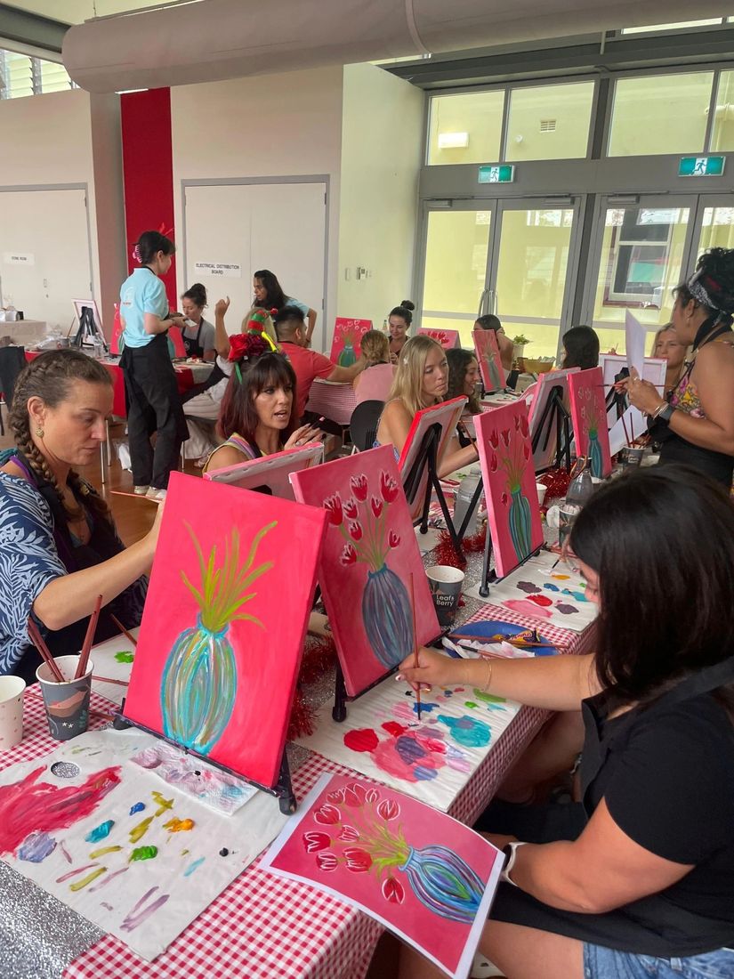 Guests painting at long tables